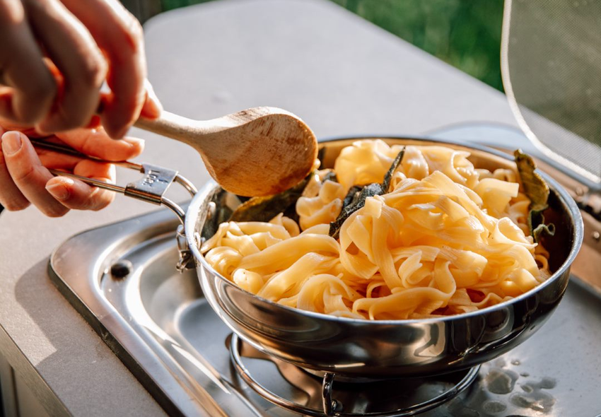 Tilberedning af tagliatelle i autocamperkøkkenet på en Etrusco Alkove Autocamper Fiat – Nydelig madlavning på campingrejser.