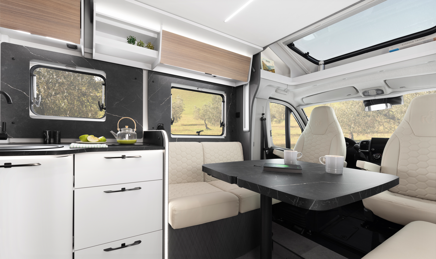 Küchenbereich eines Etrusco Teilintegrierten Fiat Wohnmobils mit Edelstahlspülbecken, geschlossenem Gasherd und Tageslicht durch ein Fenster.