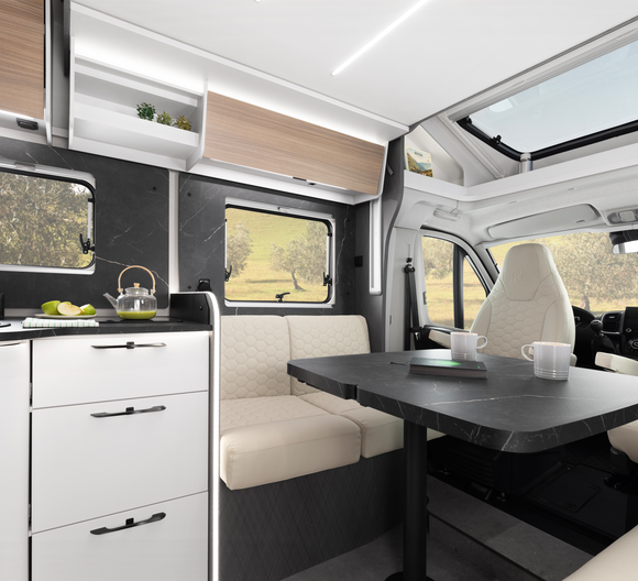Cuisine d'un camping-car partiellement intégré Fiat d'Etrusco avec évier en acier inoxydable, réchaud à gaz fermé et lumière du jour par une fenêtre.