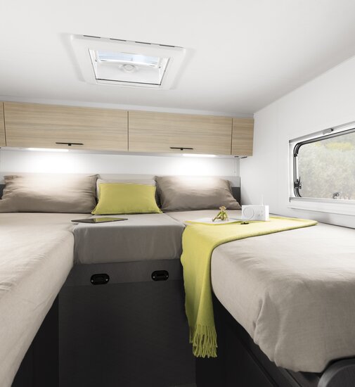Hyggeligt soveområde i den delintegrerede autocamper Etrusco Base T med harmonisk design, ideel til camping.