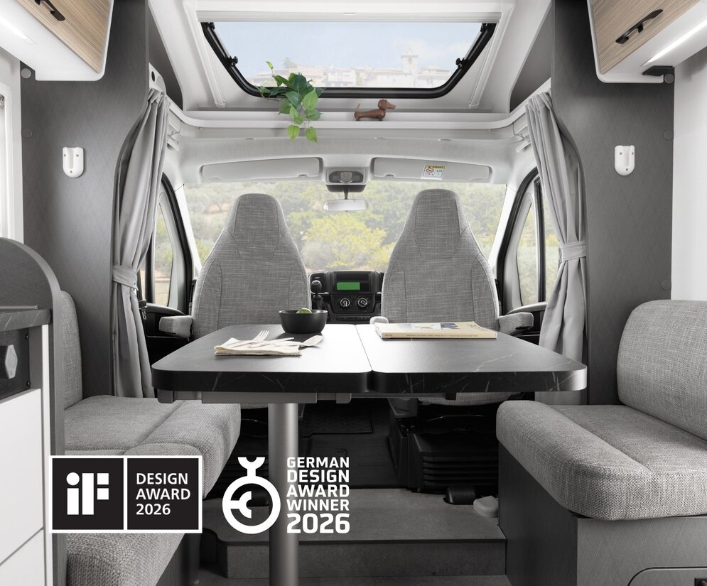Moderne opholdsområde i en Etrusco delintegreret Fiat autocamper med komfortabel spiseområde og udsigt til soveområdet.