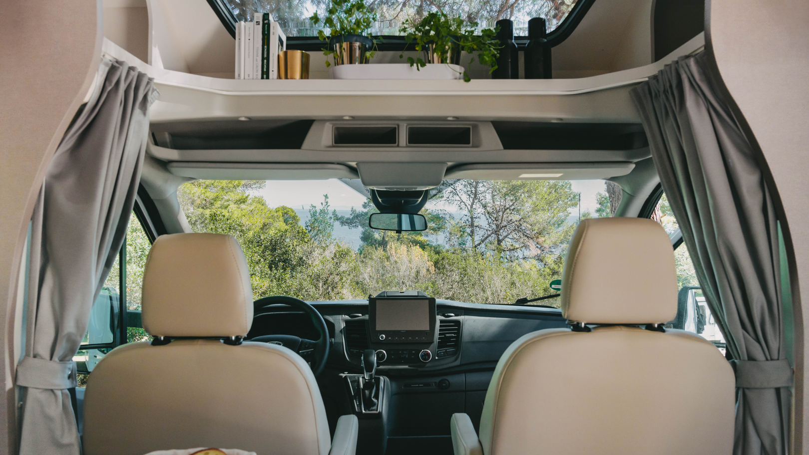Interiør af en Etrusco delintegreret autocamper på Ford-basis med panoramaudsigt og elegant cockpit.