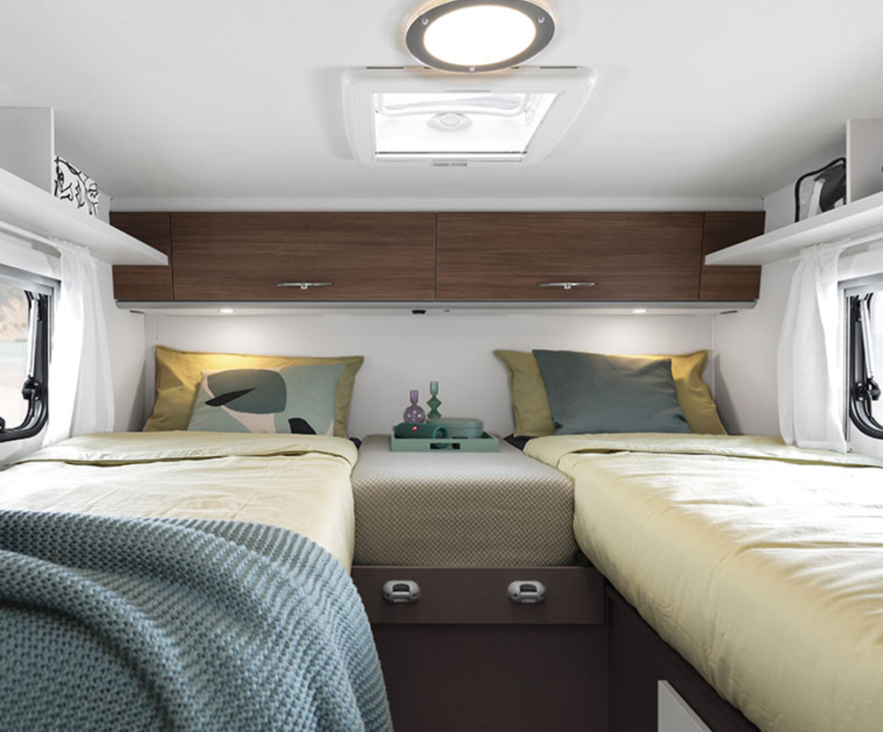 Interiør af en Etrusco delintegreret autocamper på Ford-basis med hyggelige enkeltsenge og moderne design.