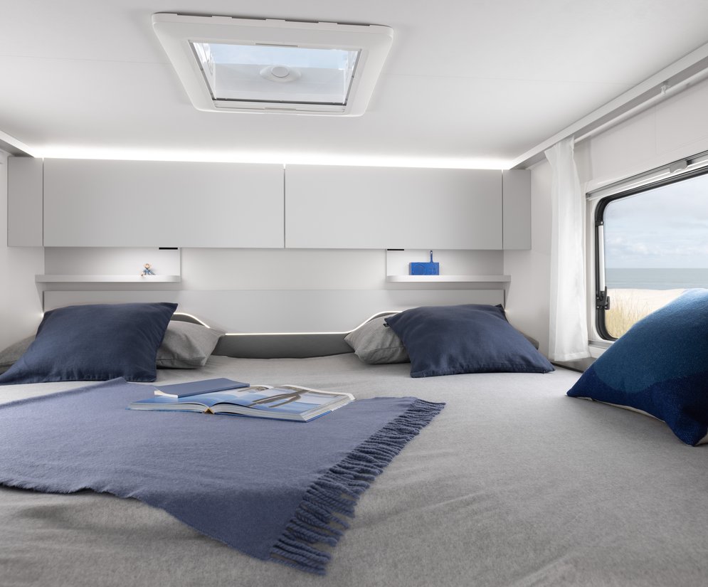 Moderner Innenraum eines integrierten Fiat Wohnmobils von Etrusco mit Küchenzeile, Doppelbett und Stauraum – ideal für Camping.
